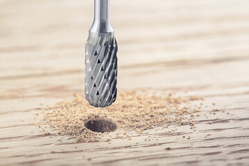 drill bit or milling cutter make hole in wooden oaks plank