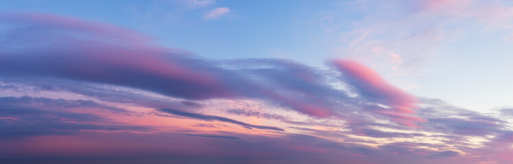 Scenic pink purple clouds against azure sky at sunset. Majestic vanilla sky panoramic shot. Beautiful pastel colored  evening skyscape. Paradise heaven.