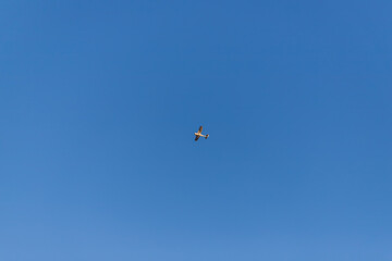 Naklejka na ściany i meble Small sport airplane in the blue sky without clouds.