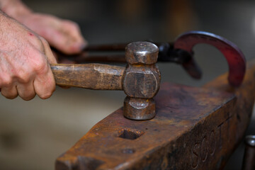 A farrier adjusting a horseshoe 