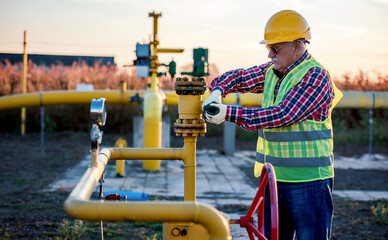 Worker checking valves on the fuel supply systems. Concept of industry