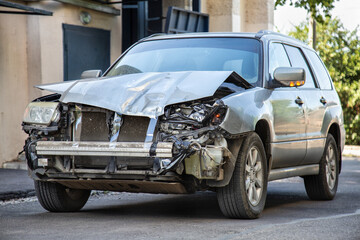 Crashed car in car accident. Broken vehicle after fatal disaster. Road collision damage. Gray car...