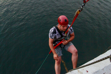 Rope jumping from high altitude of bridge. Bungee jumping from pedestrian bridge over beautiful...