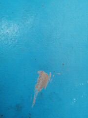old uneven dirty blue painted surface with damage underneath