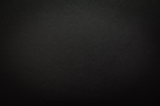 Black texture, background with vignette. Textured black board for backgrounds or lettering. Close-up.