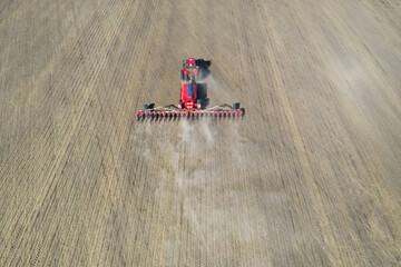 A farmer in a tractor prepares land with a sowing cultivator as part of pre-sowing work at the...