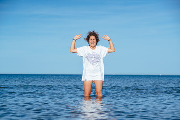 Curly girl standing in ocean