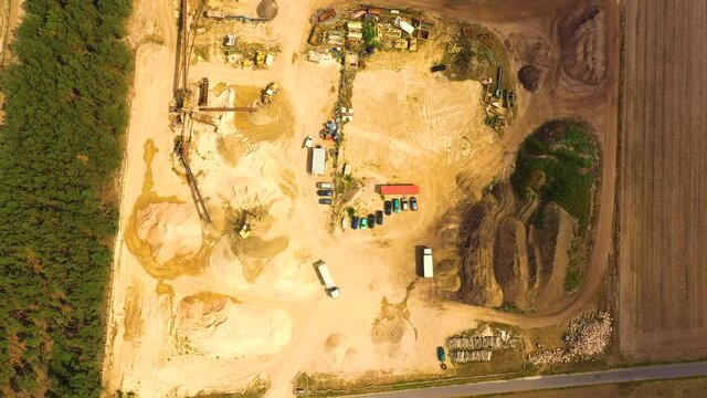 Aerial view of sandpit and factory plant producing sand materials for construction industry. Top view of large manufacturing plant in landscape