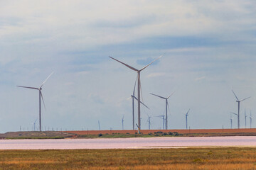 Wind turbines on a shore of the pink salty Syvash lake in Kherson region, Ukraine. Renewable energy