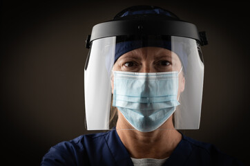 Fototapeta na wymiar Female Medical Worker Wearing Protective Face Mask and Gear Against Dark Background