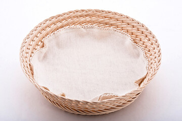 Empty wicker basket with cloth napkin, isolated on white background