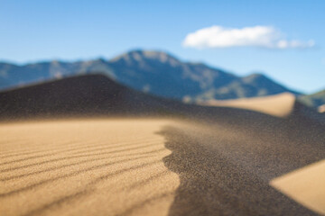 Close up of grains of sand flying in wind above ground in great sand dunes national park in america