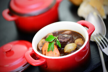 Boeuf bourguignon in einem  Topf mit Baguette 