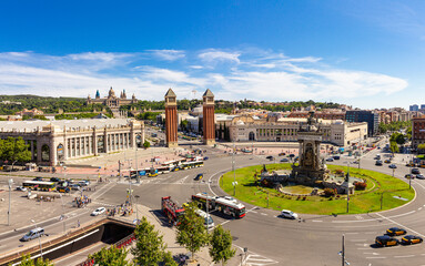 Fototapeta na wymiar Aerial rooftop view of Placa d'Espanya or Plaza de Espana or Spanish Square and Fountain Of Montjuic in summer sunny day. National Museum of Art on background. Barcelona - capital of Catalonia, Spain