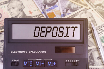 On the table are dollars and a calculator on the electronic board which says DEPOSIT