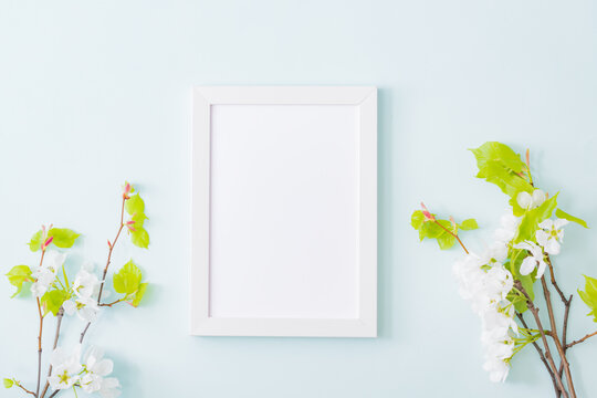 Mockup with a white frame with spring flowers on a light background