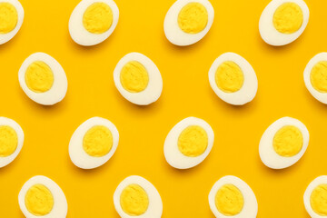 Fresh farm chicken boiled half cut eggs pattern on yellow background. Healthy food or Happy Easter creative minimal concept. Flat lay, top view