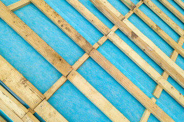 Top down detail of a wooden roof frame on a house under construction.