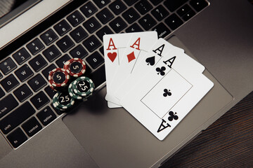 Gambling chips and playing cards on keaboard. Online casino concept.