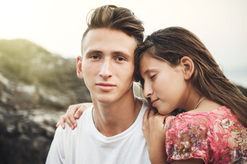 The sister closes her eyes and gently hugs her brother. The Two Caucasian siblings brother and sister posing. Portrait of a brother and sister with blonde hair, hugging, feeling care and love