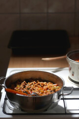 Cooking tomato, vegetable and minced meat sauce at home. Selective focus.