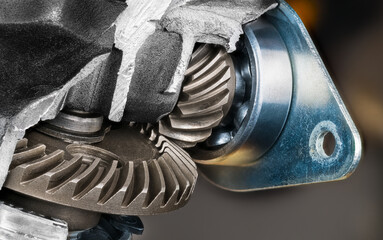 Steel cogged wheels inside detail of broken machine box of aluminum alloy. Close-up of metal gear mechanism and rolling-element ball bearings in cages in damaged angle grinder. Mechanical engineering.