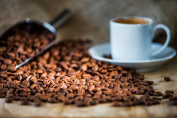 Cup of coffee on wooden table with coffee beans 