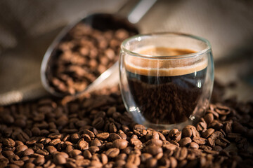 Cup of coffee on wooden table with coffee beans 