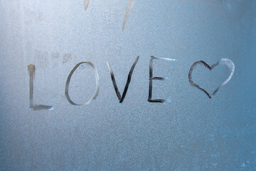 the word love and heart written on frosted glass