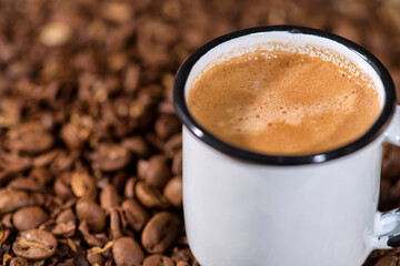 Cup of coffee on wooden table with coffee beans 