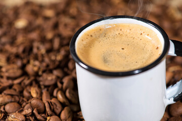 Cup of coffee on wooden table with coffee beans 