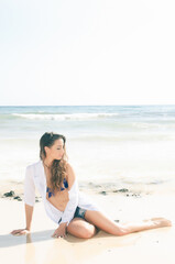 Fototapeta na wymiar very attractive and sensual young woman enjoying the sun on the seashore in spring or summer