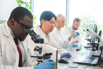 Fototapeta premium Scientist and students working in lab. Doctor teaching interns to make analyzing research. Biotechnology, chemistry, bacteriology, virology, dna and health care concept.