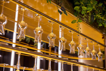 Selective focus of clean empty wine glasses hanging in bar counter