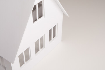 Building layout close-up. Miniature model of a two-story house. Cottage with a triangular roof. Three-dimensional model of a building as a symbol of architectural design. Building design