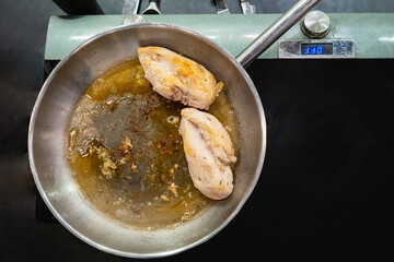 Chicken breast is fried in a pan. Chick meat breast during cooking. Concept - recipes for dishes with chicken meat. Recipes of dishes with chicken meat. Hot handling of birds.