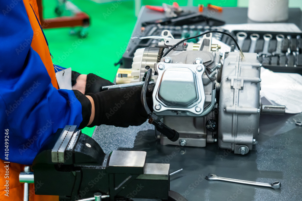Poster hands of a car foreman during work. he's fixing some car part. man in a uniform works with auto part