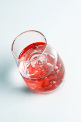 Valentine's Day. Small red glass hearts in a glass of water. A splash of liquid.