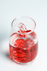 Valentine's Day. Small red glass hearts in a glass of water. A splash of liquid.
