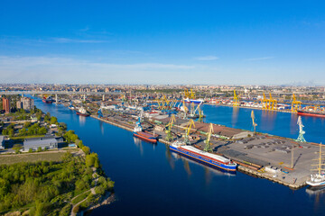 Fototapeta na wymiar Bird's eye view of seaport. Seaport on a summer day. Freight boats off coast of sea port. Concept of cargo transportation by sea. Cargo transportation through seaport. Services for sea freight