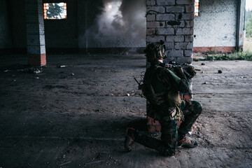 Obraz premium Military soldier in the form holds in the hands an assault rifle, check possible enemies around the corner
