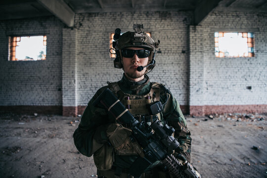 Military Man With Assault Rifle Standing Inside Building, He Is Ready For Combat