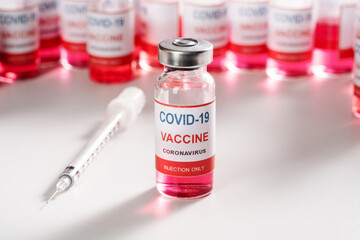 glass vaccine vial for vaccination against COVID-19 SARS-CoV-2 coronavirus pandemic on white background