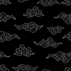 Decorative Asian white clouds on a black background. Seamless nature doodle pattern. Suitable for packaging, textile, wallpaper.
