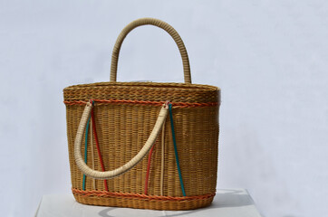 A traditional colourful rattan basket with handles