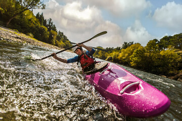 Whitewater kayaking, extreme sport rafting. Guy in kayak sails mountain river.