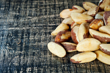 Brazil nut on a black shabby board. Nuts texture on a wooden table. Copy space and free space for text near nuts.