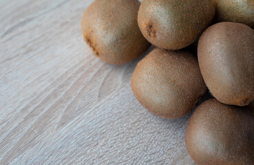 Fototapeta premium Group of ripe whole green kiwi fruit on a wooden table
