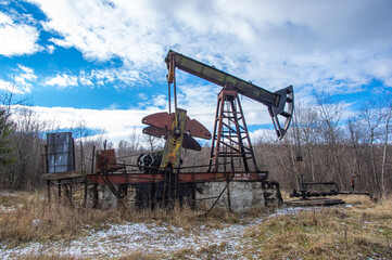 Old abandoned oil pump in the middle of the forest