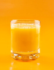 Orange juice in a glass on an orange background. Concept. Healthy eating.